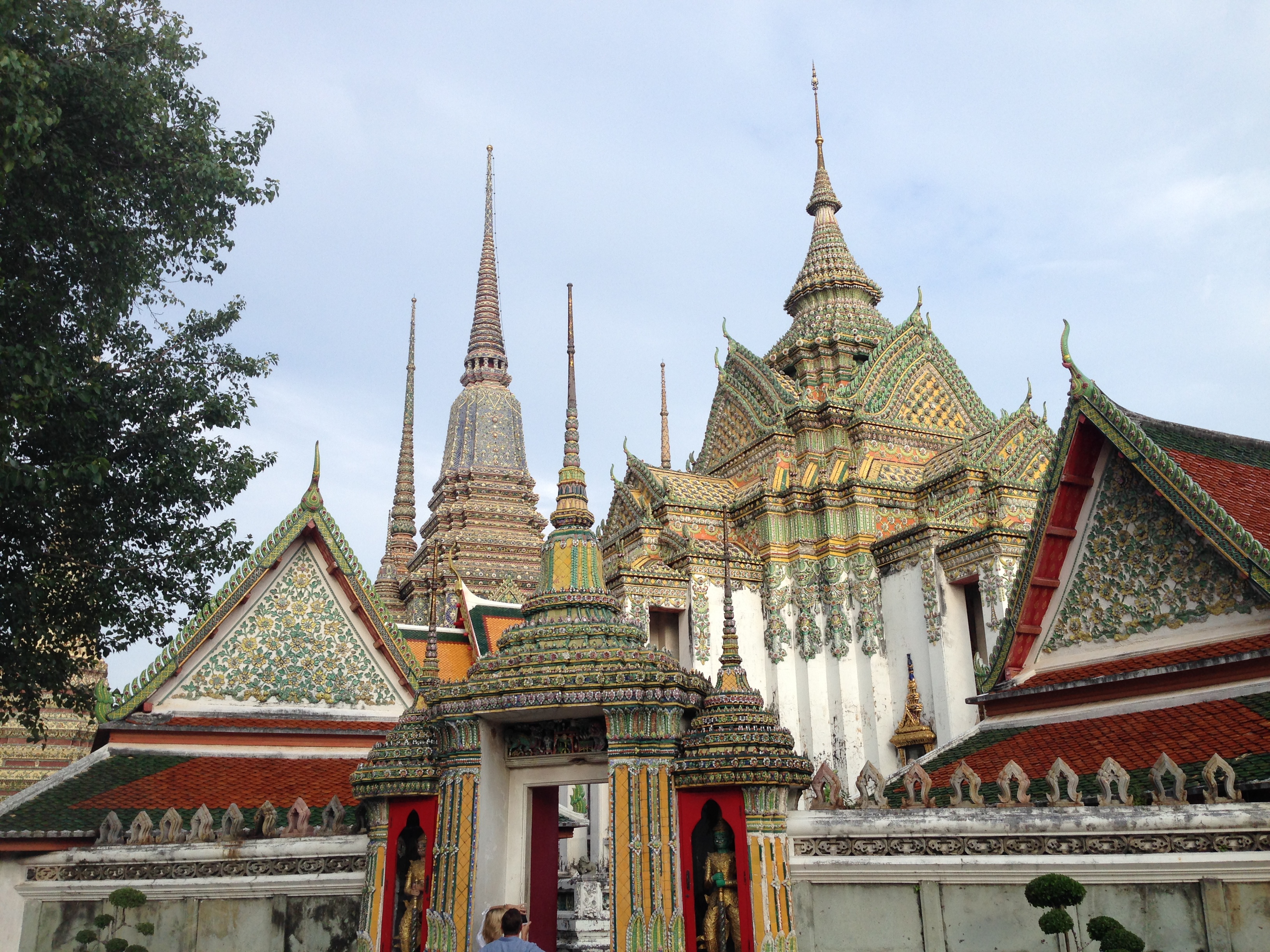 a colorful ornate building with spires with Wat Pho in the background