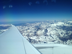 an airplane wing and snowy mountains
