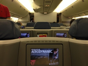 the inside of an airplane with seats and a television screen