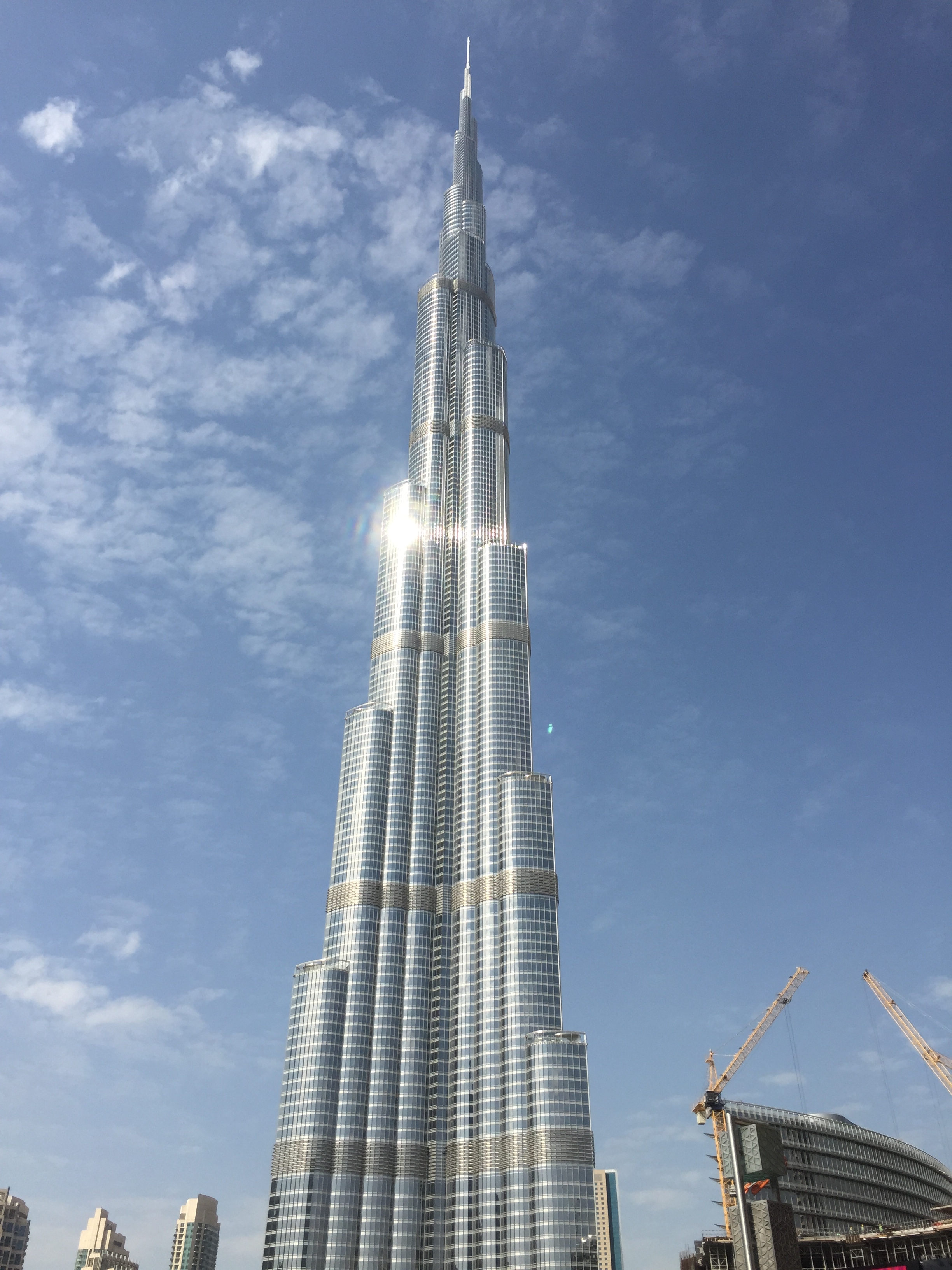 a tall building with many windows with Burj Khalifa in the background